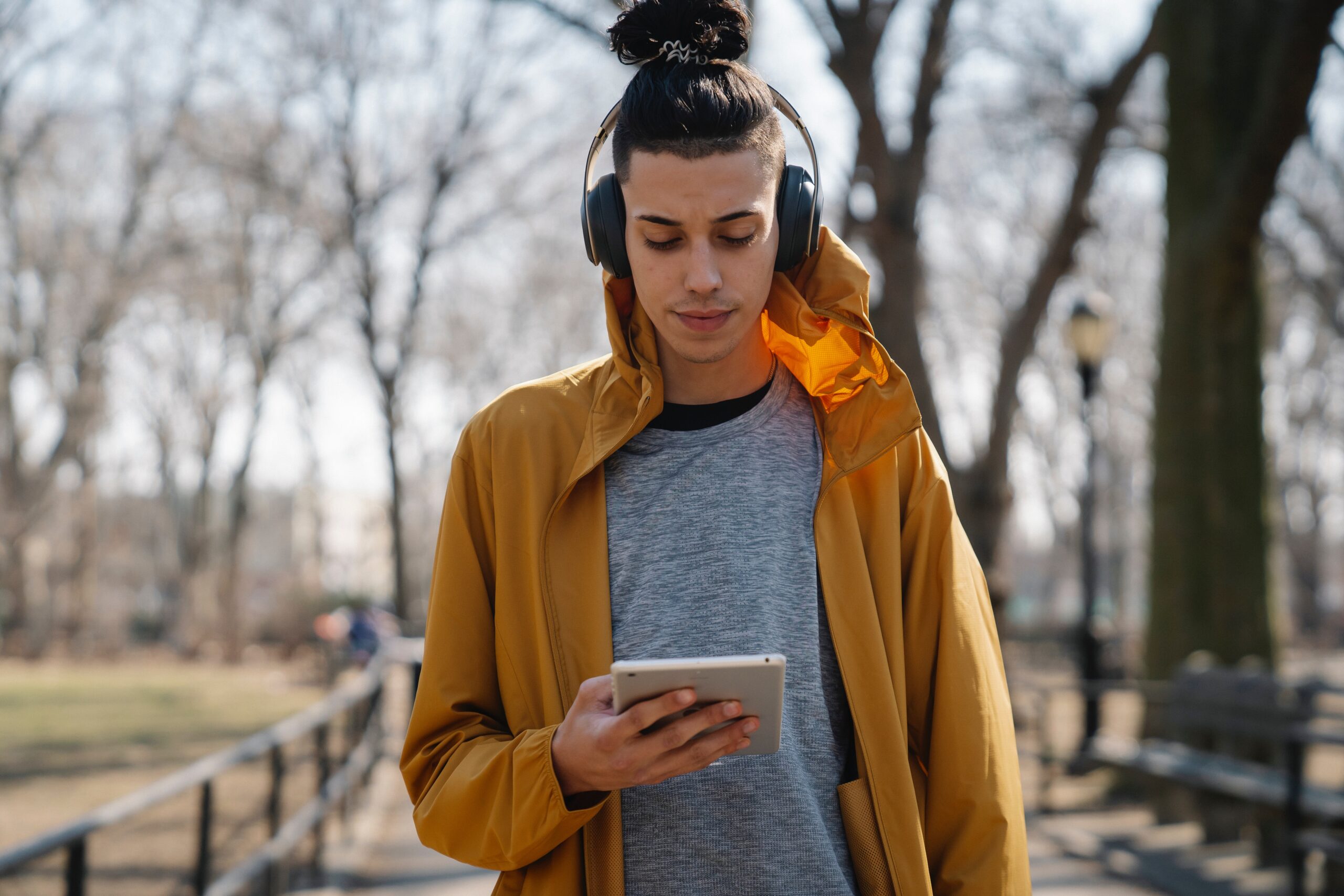 A guy with headphones listening to music on a tablet